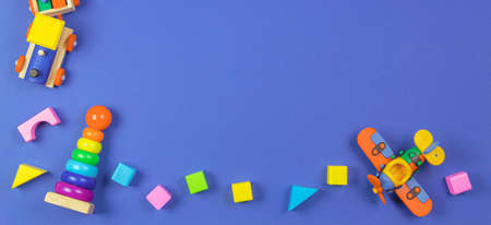 Baby kids toys banner background. Wooden educational natural toys on navy blue background. Top view,...