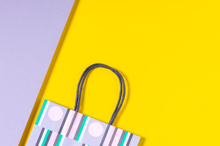 Colorful paper shopping bag on yellow and gray background. Top viewの写真素材