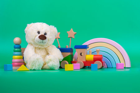 Teddy bear, wooden rainbow, train and baby toys on  greenの写真素材