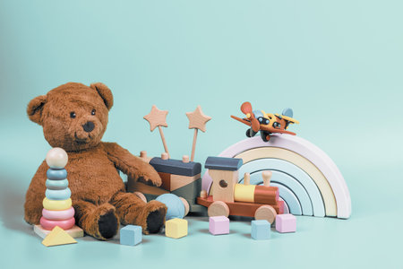 Teddy bear, wooden rainbow, train and baby toys on light blueの写真素材