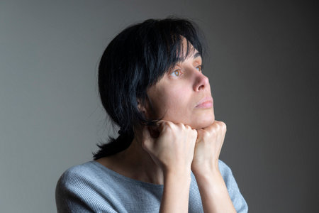 Face yoga, facial gymnastics, daily self care routine. Middle age caucasian woman performing facial...