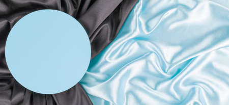 Geometric platform podium on light blue silk satin background. Blank minimal cylinder form mock up background for cosmetic product presentationの写真素材