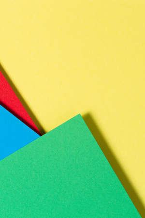 Abstract color papers geometry flat lay composition background with blue, yellow, red and green...
