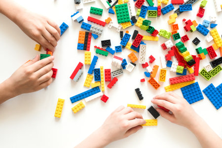 Vilnius, Lithuania - April, 2017. Children hands play with colorful lego blocks on white tableのeditorial素材