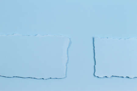 Abstract monochrome background. Pieces of torn paper on light blue background. Top view