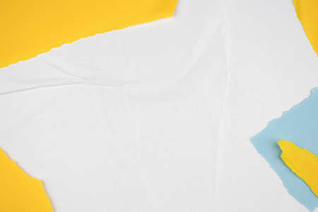 Old ripped torn paper background in white, yellow, blue colors. Blank creased crumpled dirty posters...