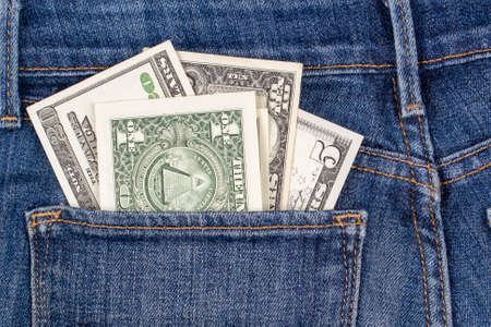 American dollars banknotes peeking out of blue jeans back pocket. Money, personal finance, tax...