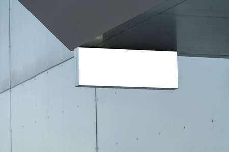 Blank white rectangular mock up street signboard on gray wall outdoors