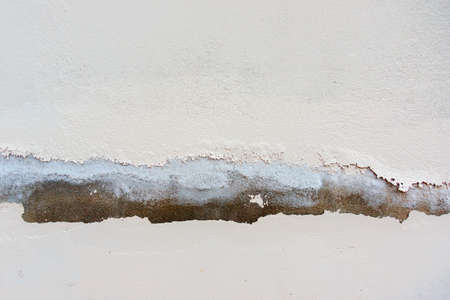 White color painted old peeling cracked plaster wall background