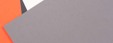 Creative abstract geometric colored paper background in orange, light gray, white, black colors