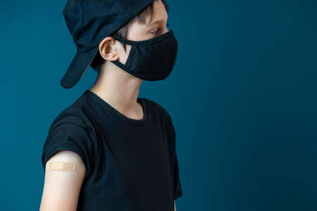 Teenage boy with plaster on his arm after vaccination. Vaccine and health care for childen and teenagersの写真素材