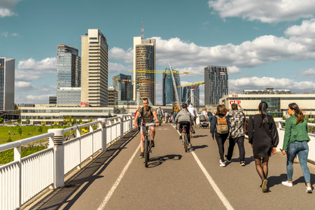 Vilnius, Lithuania - May 30, 2021: People walking, riding bikes and scooters on White bridge. Vilnius cityscape with Neris riverのeditorial素材