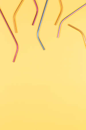 Multicolored reusable stainless steel straws on pastel yellow background. Top view, copy spaceの写真素材