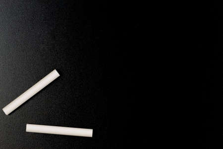 Blank blackboard, chalkboard with two chalk crayons for writing. Education, learning, back to school conceptの写真素材