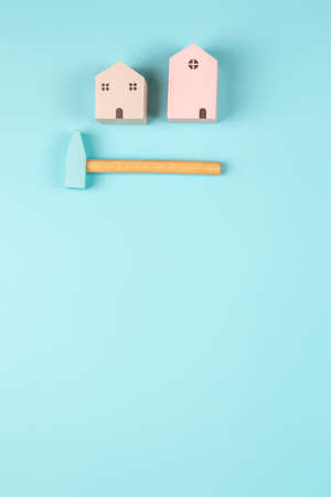 Small wooden houses and hummer on light blue background. New house construction, repair maintenance, DIY at home, real estate property conceptの写真素材