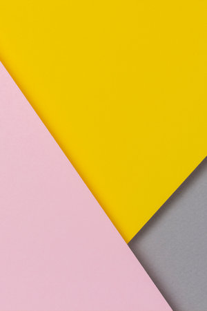 Creative abstract yellow, pink and gray color geometric paper compositon background, top viewの写真素材