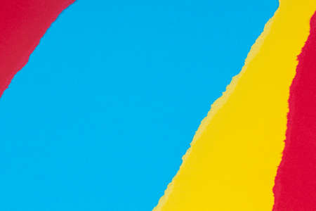 Torn grunge ripped yellow, blue, red geometric paper background. Colorful torn paper collage wallpaperの写真素材