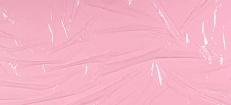 Crumpled wrinkled plastic transparent plastic cellophane on light pink color background. Abstract creative texture backgroundの写真素材