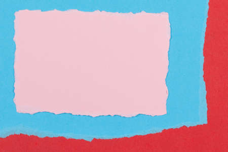 Torn paper textured collage background. Grunge ripped pastel pink paper piecs with ragged edge on geometric blue and red paper backgroundの写真素材