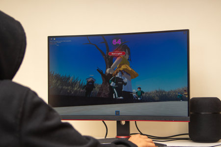 Vilnius, Lithuania - October 09, 2021: Teenager playing video game Squid Game on computer at home....