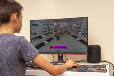Vilnius, Lithuania - October 09, 2021: Teenager playing video game Squid Game on computer at home. Squid game released in Roblox global gaming platform according to Korean drama series in Netflixのeditorial素材