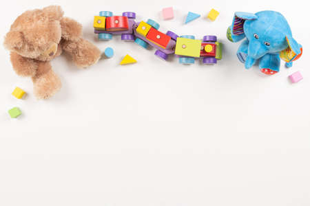 Baby kids toys frame. Colorful educational wooden and fluffy toys for children arranged on white background. Top view, flat layの写真素材