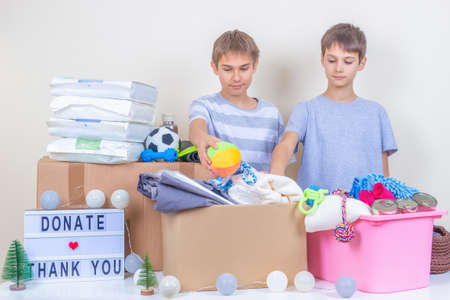 Animal shelter Christmas donations. Volunteer teenagers collecting donations, preparing animal donation box for animal shelters at Christmas charityの写真素材