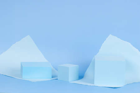 Abstract monochrome composition with empty rectangular podium platform for product presentation and torn paper edges on light blue background. Front viewの写真素材