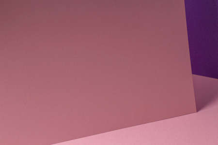 Blank pastel pink paper sheet card note with shadows on pink and violet purple background. Abstract geometric monochrome pink background with copy space for text. Front diagonal viewの写真素材