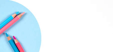 Light blue and pink colored pencils on geometric round blue and white table background. Top view. Back to school, education, learning, art, creative entertainment conceptの写真素材