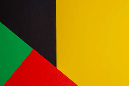 Abstract colored paper geometry composition background in black, red, yellow, green colors with copy space for textの写真素材