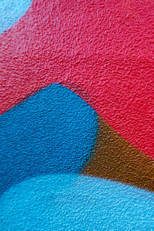 Fragment of the wall with blue red brown colors graffiti painting in the street. Part of colorful...
