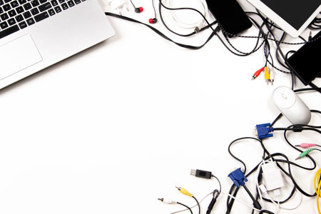 Old laptop computer, digital tablet, mobile phones, cable, cords, used electronic gadgets devices on white table. Top view. Planned obsolescence, e-waste, electronic waste for recycling conceptの写真素材