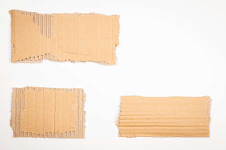 Three pieces of brown corrugated cardboard on white background. Blank ripped kraft carton paper note cards with copy space for text. Top viewの写真素材