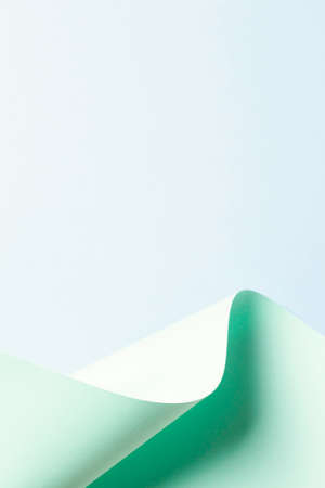 Abstract wave of pastel green paper on light blue background. Creative geometric curved paper with...