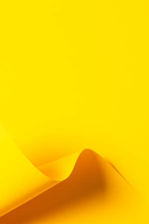 Abstract wave of yellow color paper. Creative geometric curved paper with light and shadows. Abstract geometry background with copy spaceの写真素材