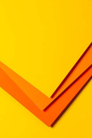 Abstract colored paper texture background. Minimal vertical composition with geometric shapes and lines in yellow and orange colorsの写真素材