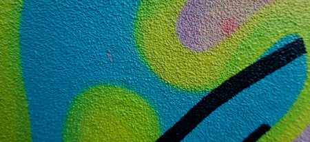 Fragment of the wall with colorful graffiti painting in the street. Part of colorful street art...