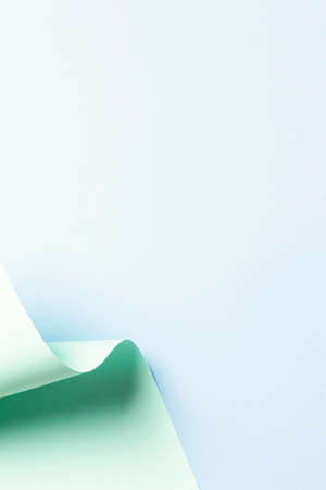 Abstract wave of pastel green paper on light blue background. Creative geometric curved paper with light and shadows. Abstract geometry background with copy spaceの写真素材