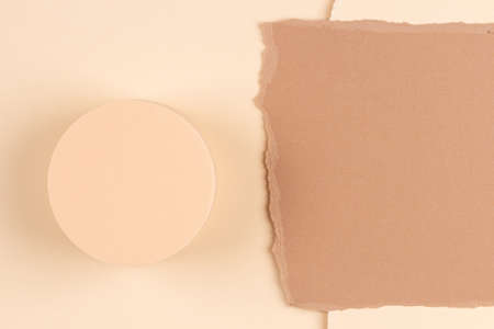 Abstract composition with empty round podium platform for product presentation and curve shaped torn paper edge on brown beige background. Top viewの写真素材