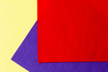 Abstract colorful geometric felt texture background. Bright yellow, blue, red colors felt textile for craft. Top view, flat layの写真素材