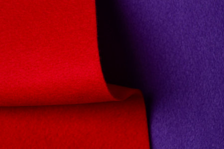 Abstract geometric felt texture background. Creative geometric curved felt textile background in blue and red colors. Top view, copy spaceの写真素材