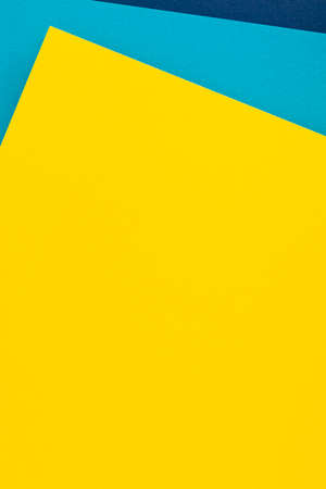 Abstract colored paper texture background. Minimal geometric shapes and lines in light blue, navy blue, yellow colorsの写真素材
