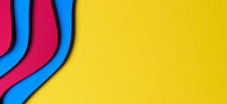 Abstract colored paper texture background. Minimal paper cut style composition with layers of geometric shapes and lines in red and light blue colors on yellow background. Top viewの写真素材