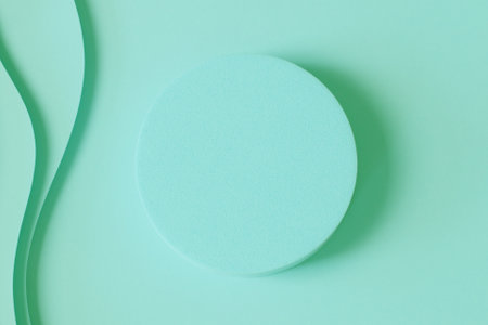 Blank round geometric shape podium platform on paper cut abstract minimal geometric shape pastel green color background. Top view mock up for product displayの写真素材
