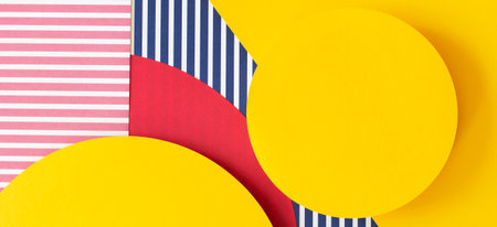 Abstract trendy fashion colored papers texture background in memphis geometry style. Yellow, red, blue, white colors. Geometric shapes and striped lines. Top view, flat layの写真素材