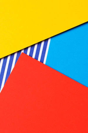 Abstract geometric fashion colored papers texture background. Yellow, red, blue and striped paper...