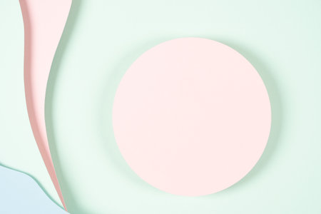 Blank pink round geometric shape podium platform on paper cut abstract geometric shape pastel pink, blue and green background. Top view mock up for product displayの写真素材