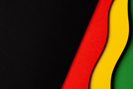 Black History Month color background. Abstract black, red, yellow, green color paper cut background with geometrical wavy lines and shapes. Top viewの写真素材