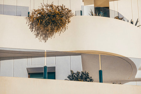 Fragment of white modern building balconies decorated with potted plantsの写真素材
